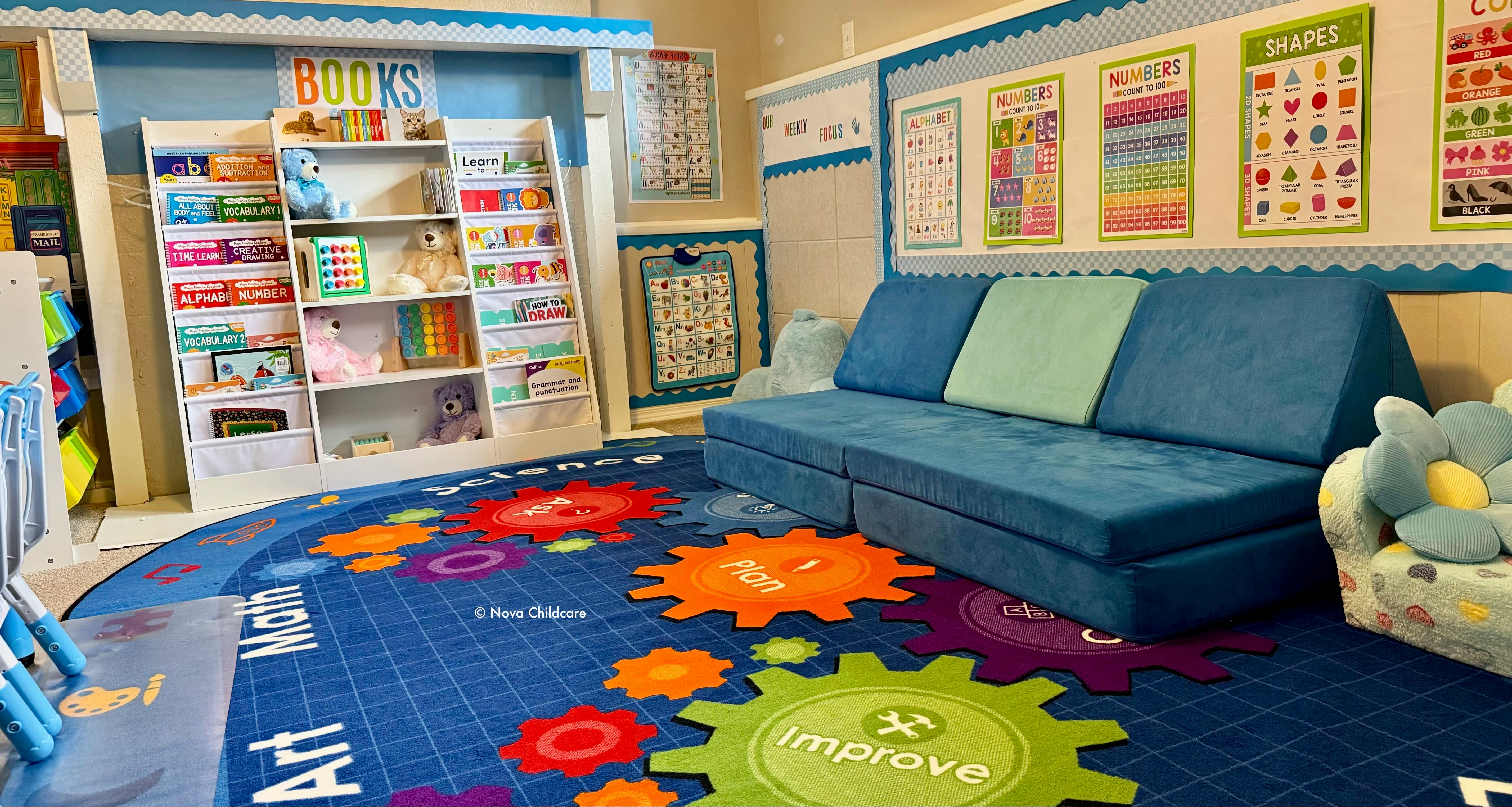 Children's play area with a blue sectional sofa, a colorful rug, and educational posters