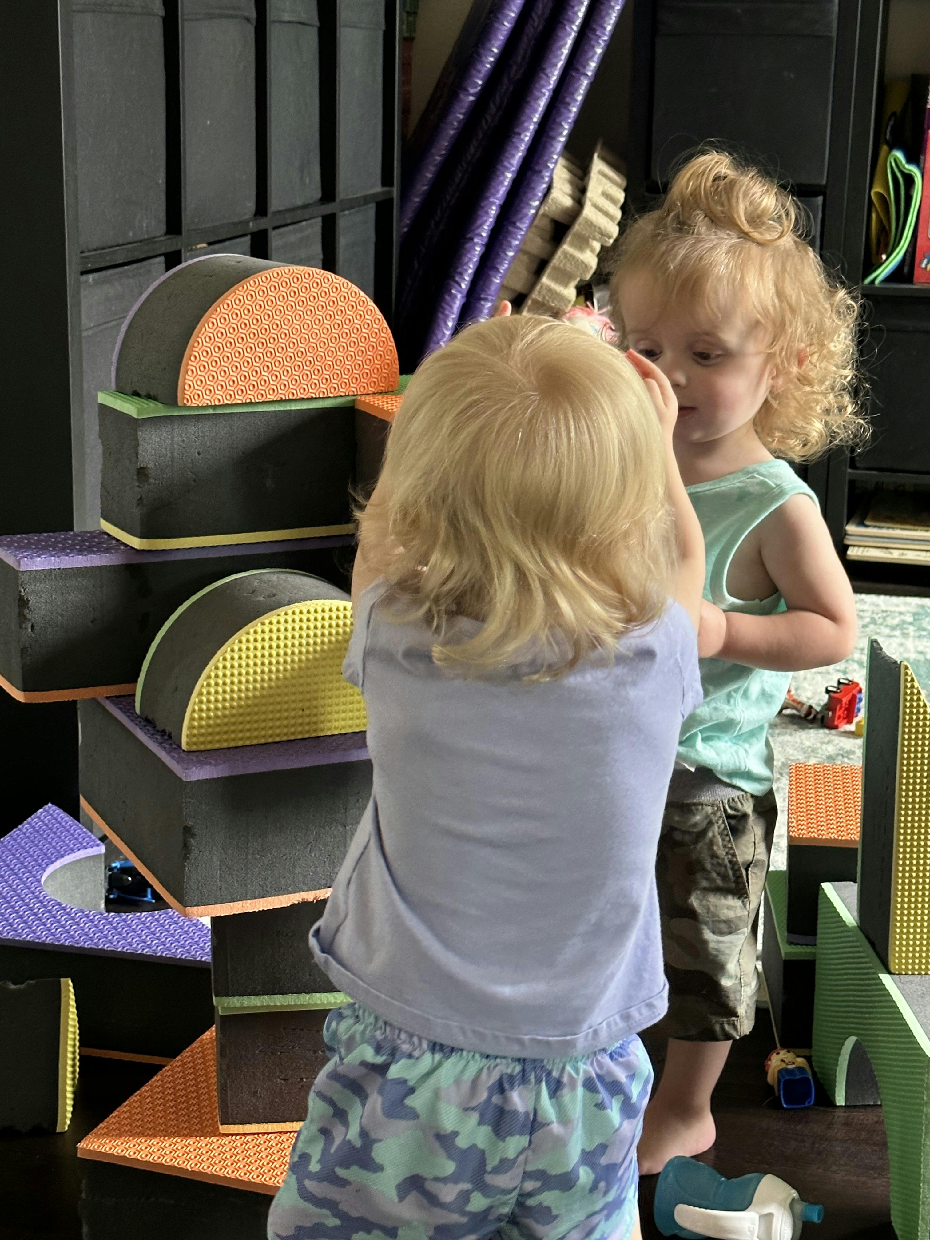 Two children playing with soft building blocks