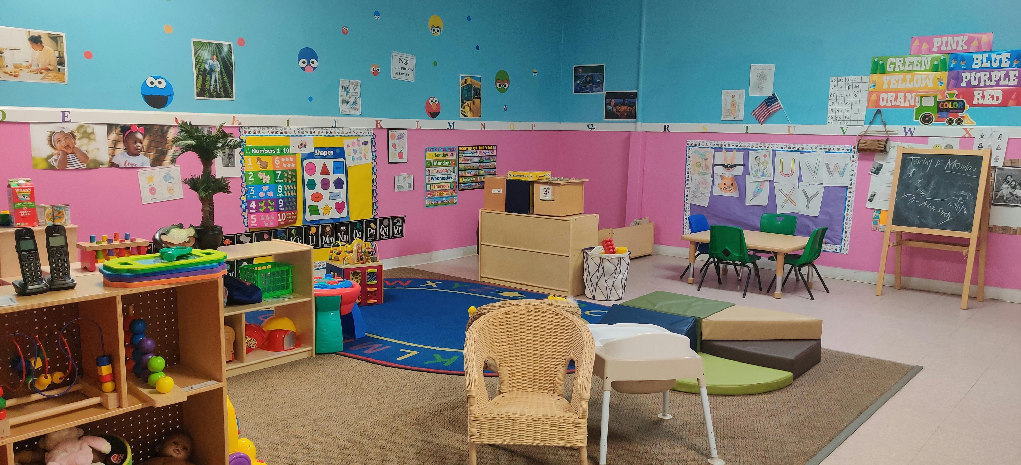 Classroom with small tables, chairs, and shelves with learning materials
