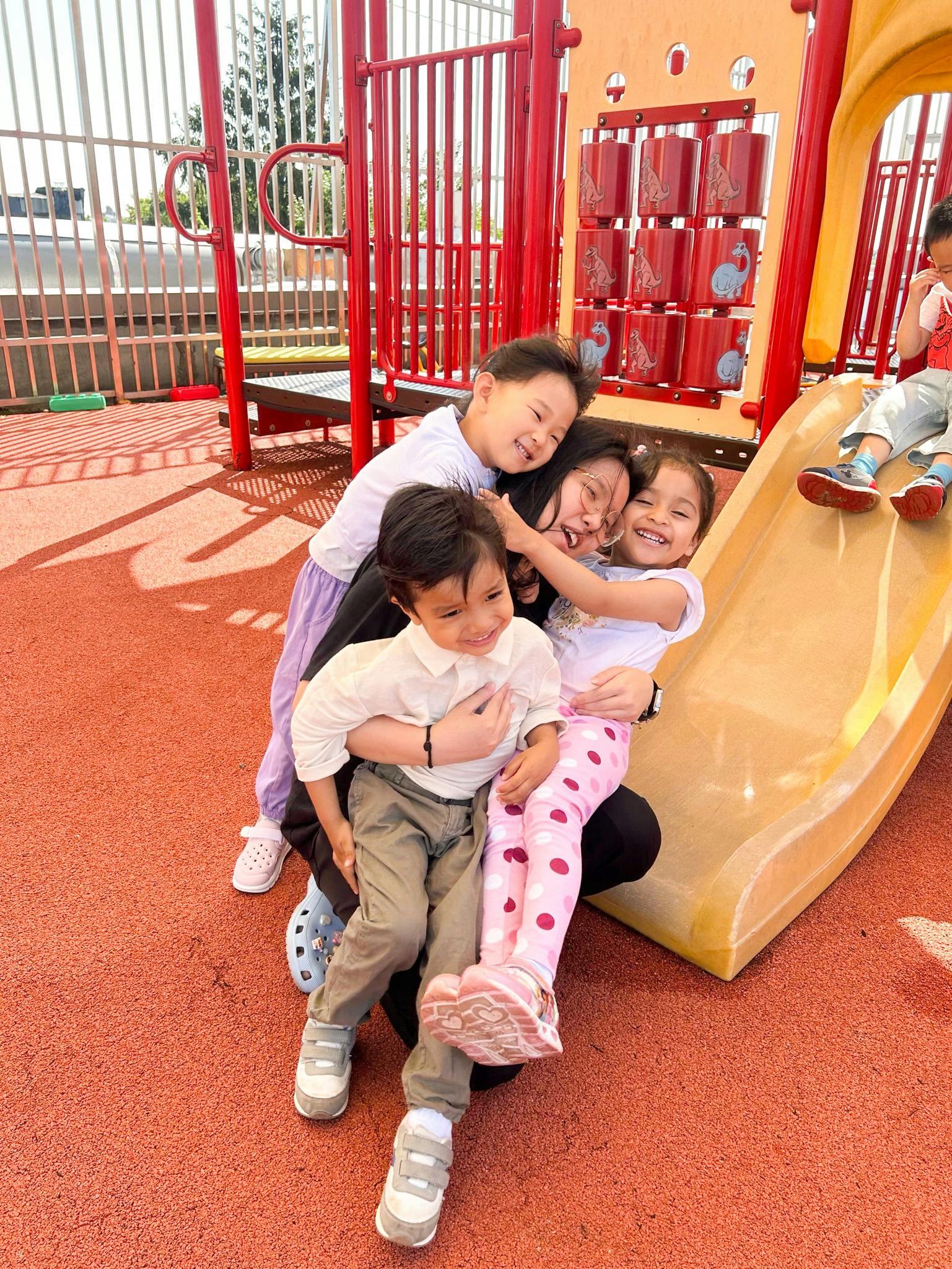 Person with three children on a playground