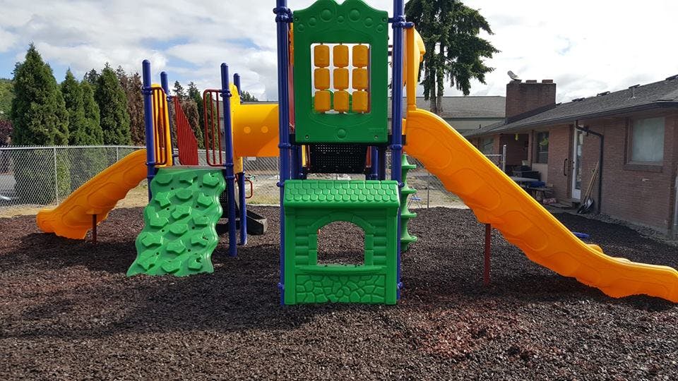 Playground structure with slides and climbing wall
