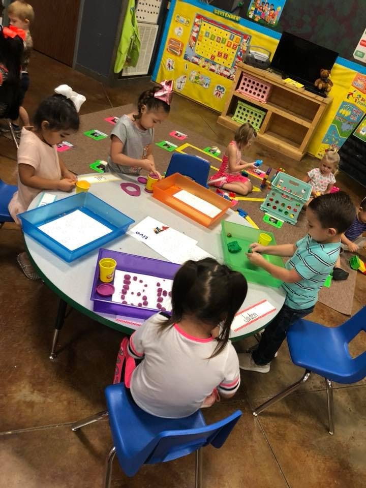 Children sitting around a table doing crafts in-class activities