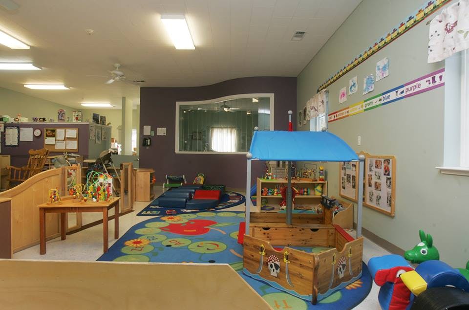 Playroom with colorful rug and play structures