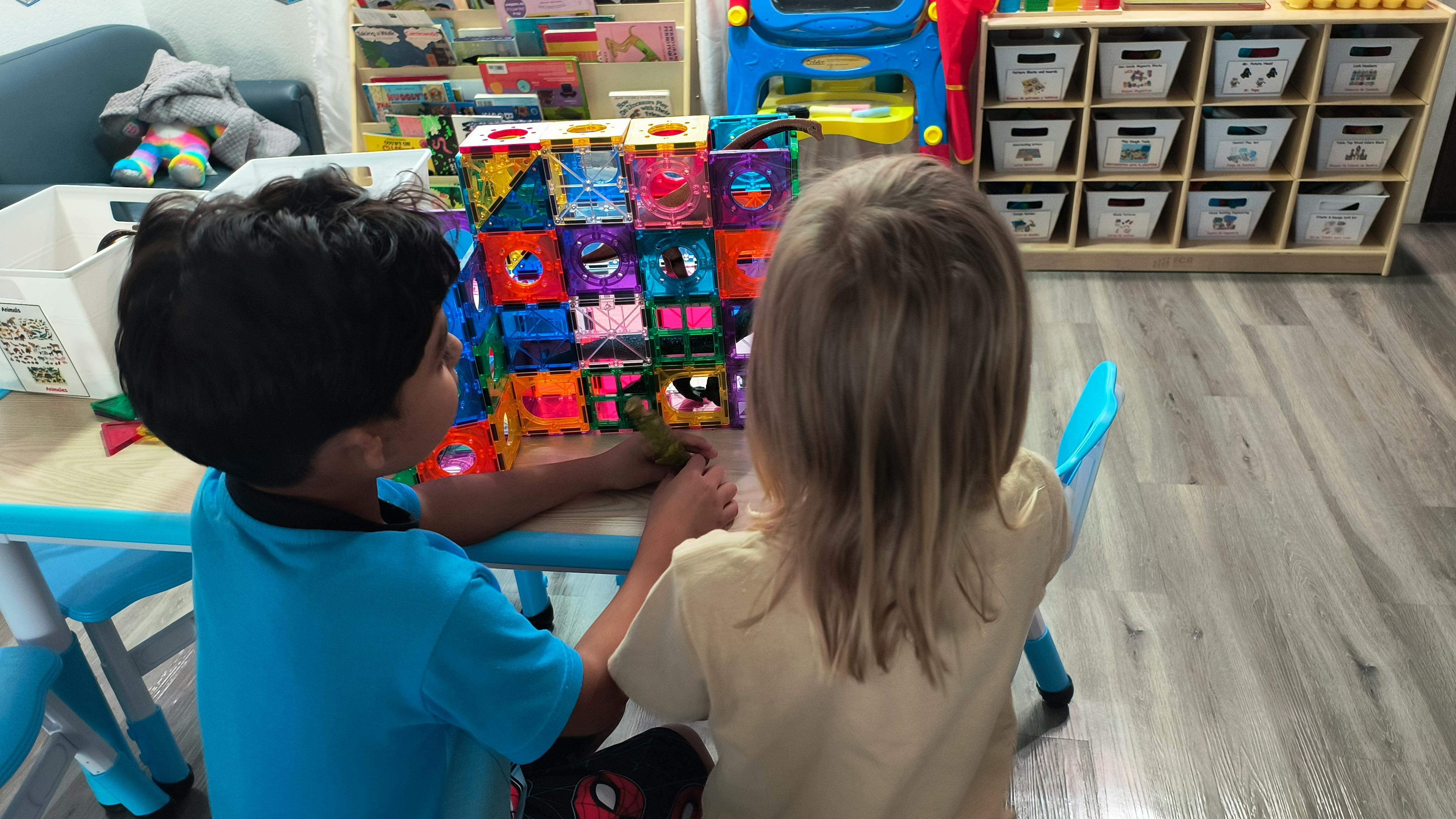 Two children playing with colorful magnetic tiles