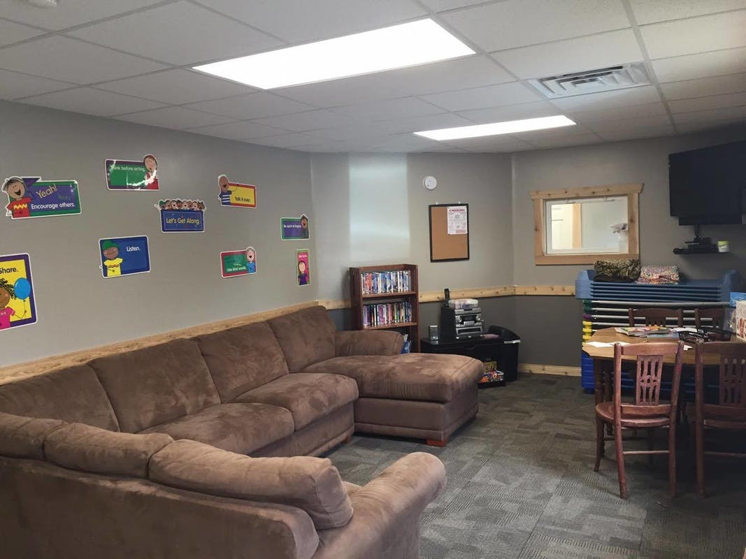 Living room with a large brown sectional sofa and a small dining area