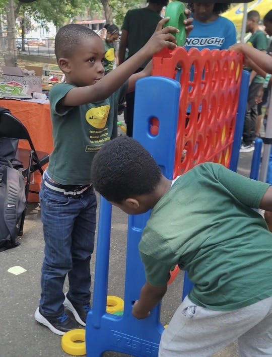 Two children playing a large vertical disc game outdoors