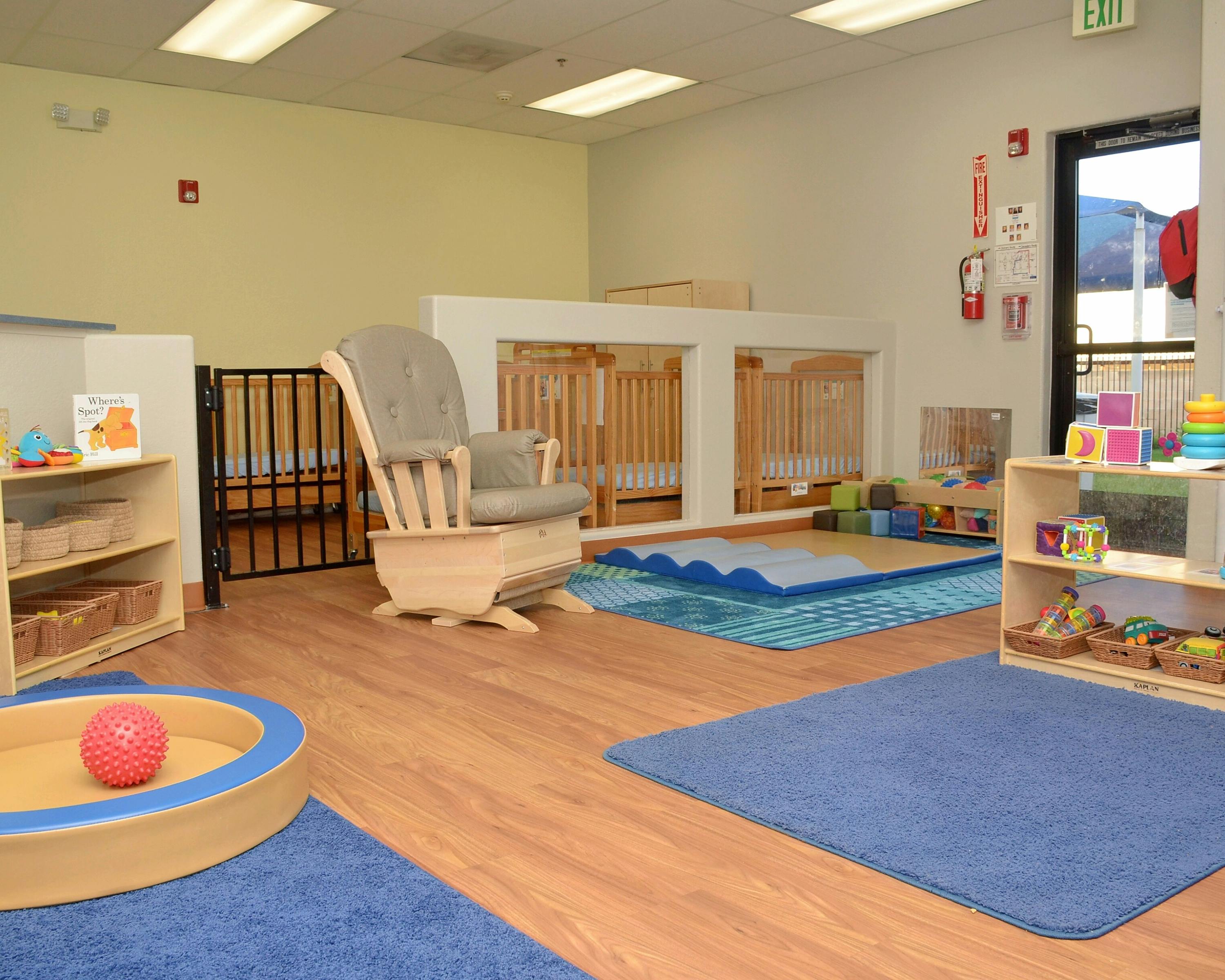 Nursery room with cribs, a rocking chair, and play mats