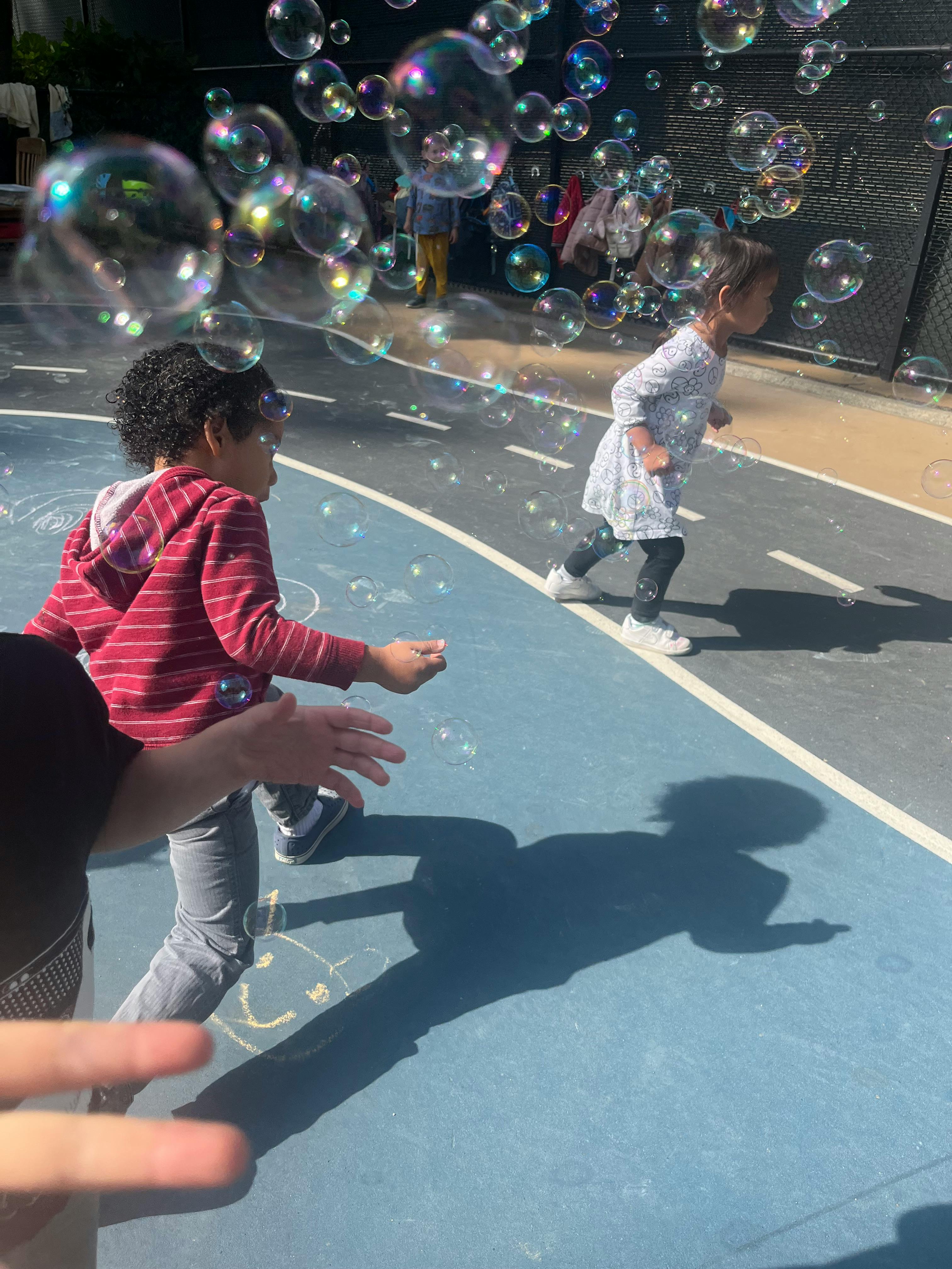 Two children playing with bubbles outdoors