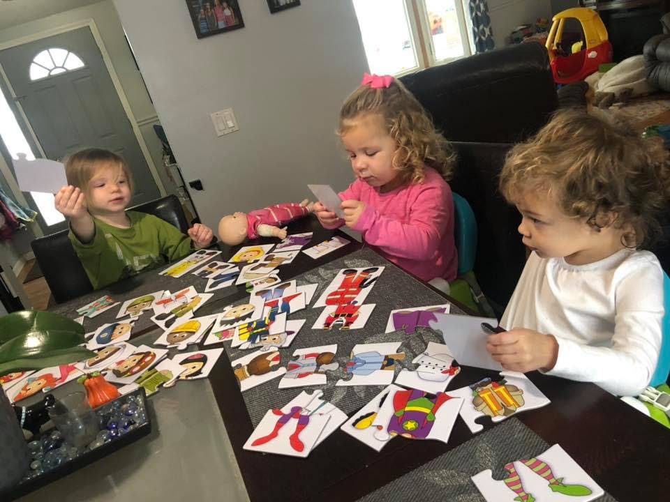 Three children playing with cards at a table