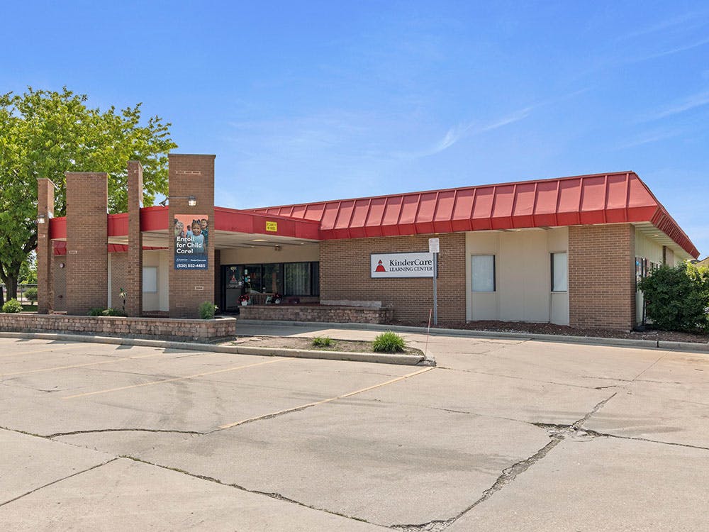 Brick building with a red roof and a KinderCare Learning Center sign