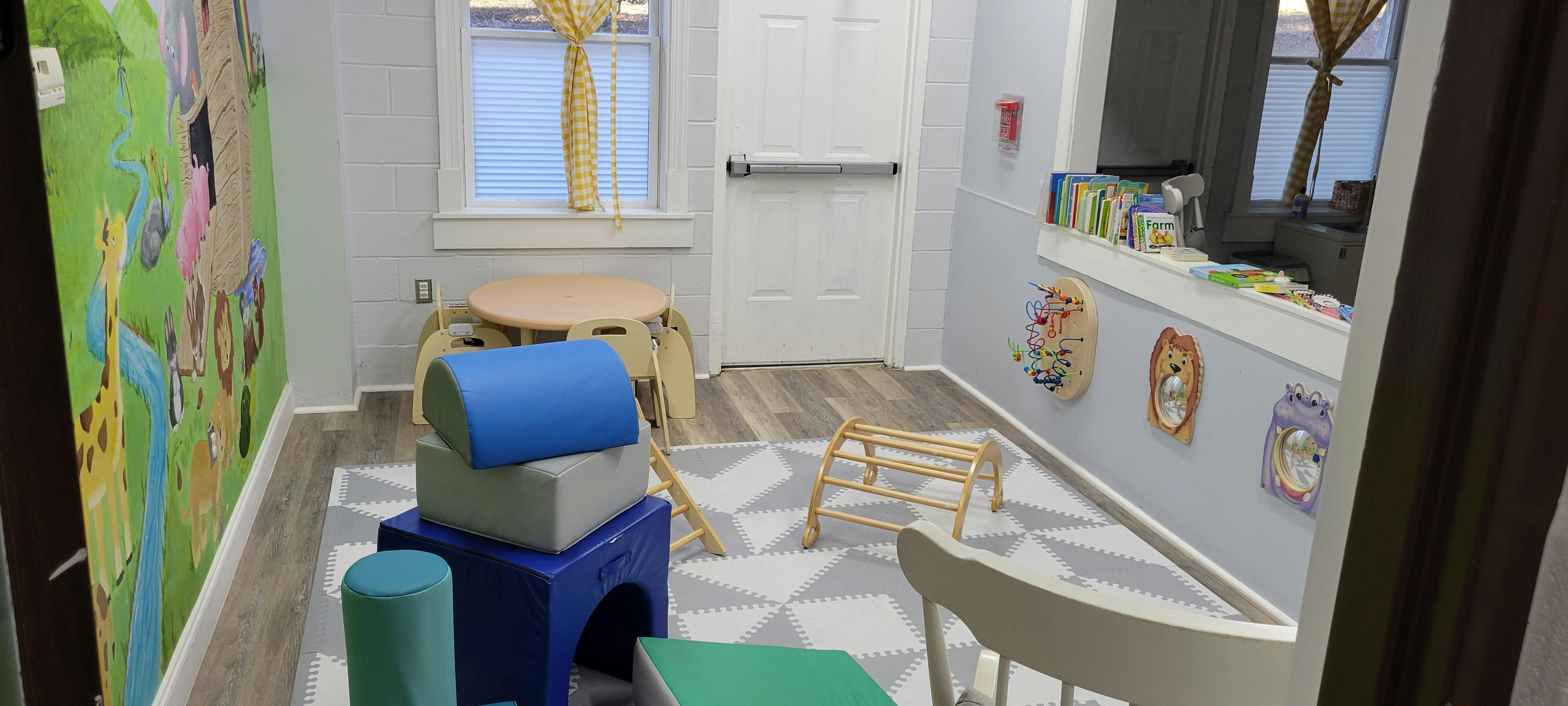 Children's play area with soft climbing blocks and a mural