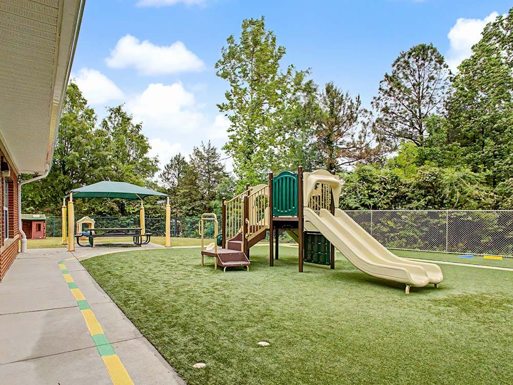 Outdoor playground with slides, play structure, and covered picnic area