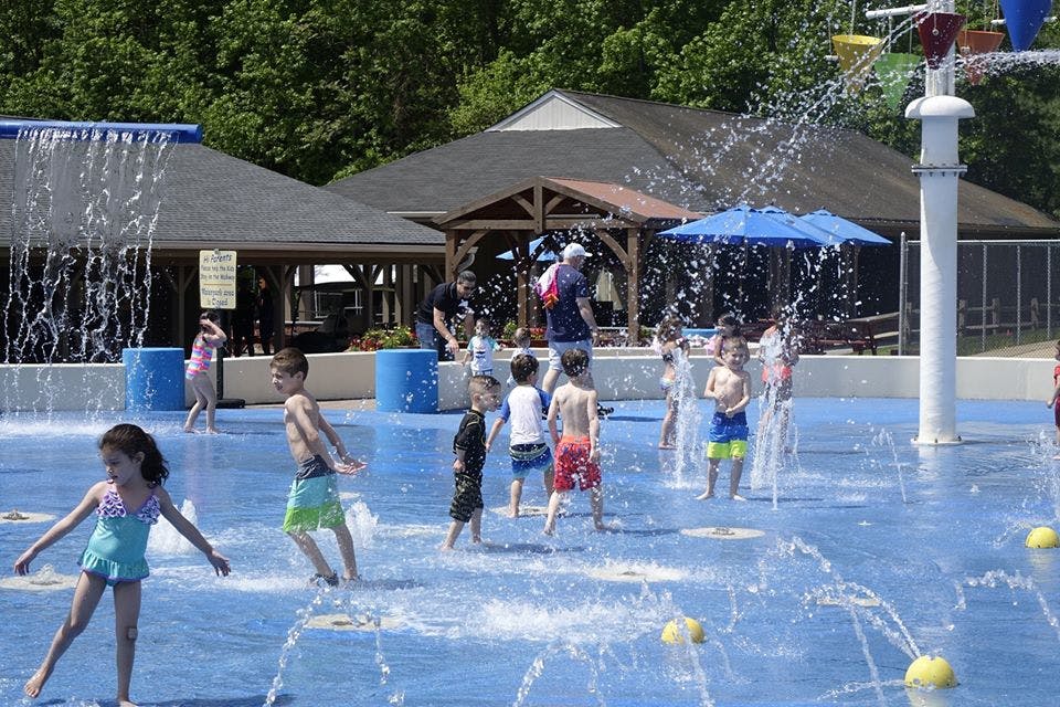 Children playing in a splash pad with water spraying