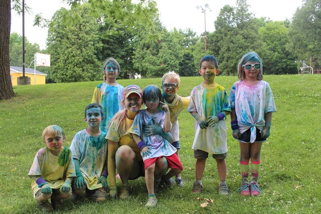 Group of children and adults covered in colorful powder