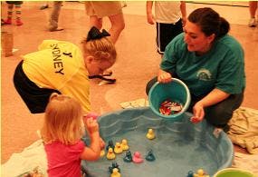 Adult and two children playing a duck pond game