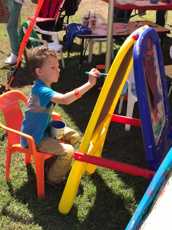 Child painting on an easel outdoors