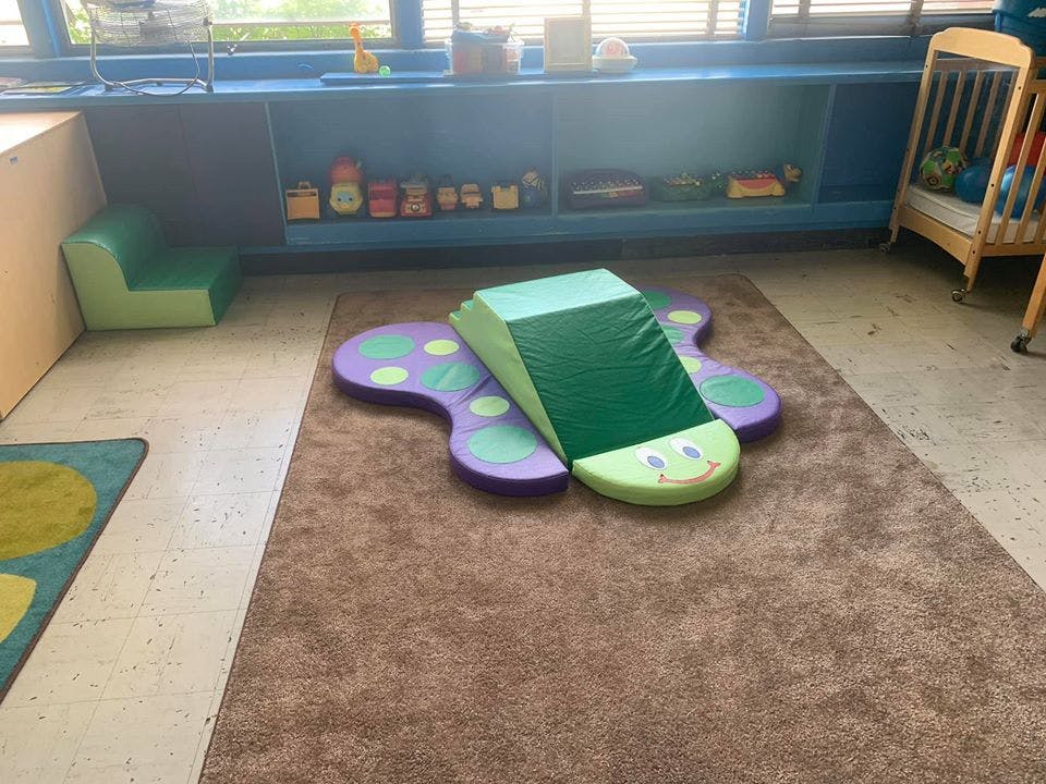 Playroom with soft play equipment on a rug
