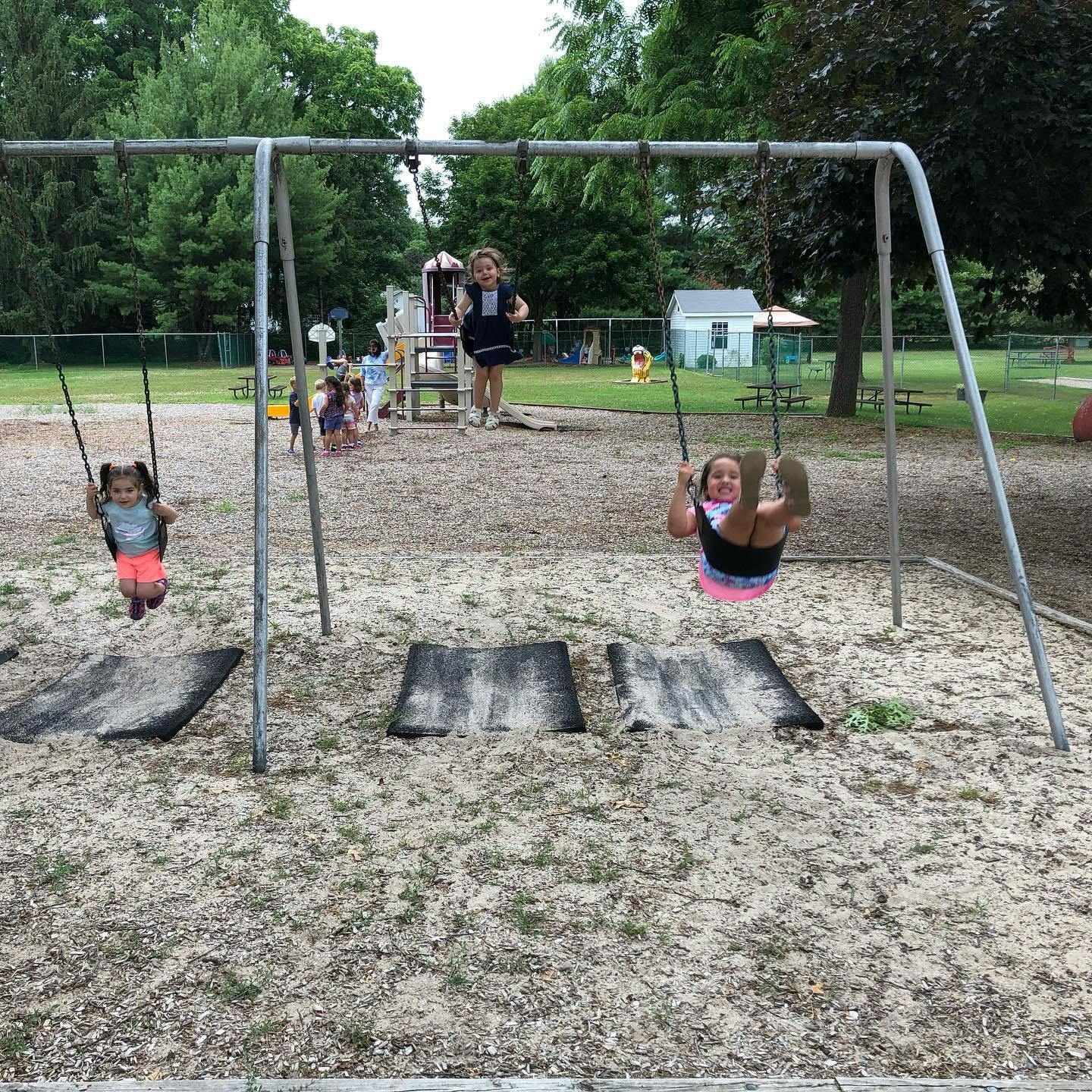 Two children swinging on a playground