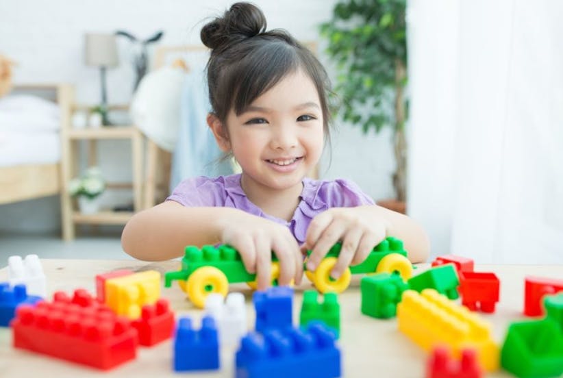 Child playing with colorful building blocks