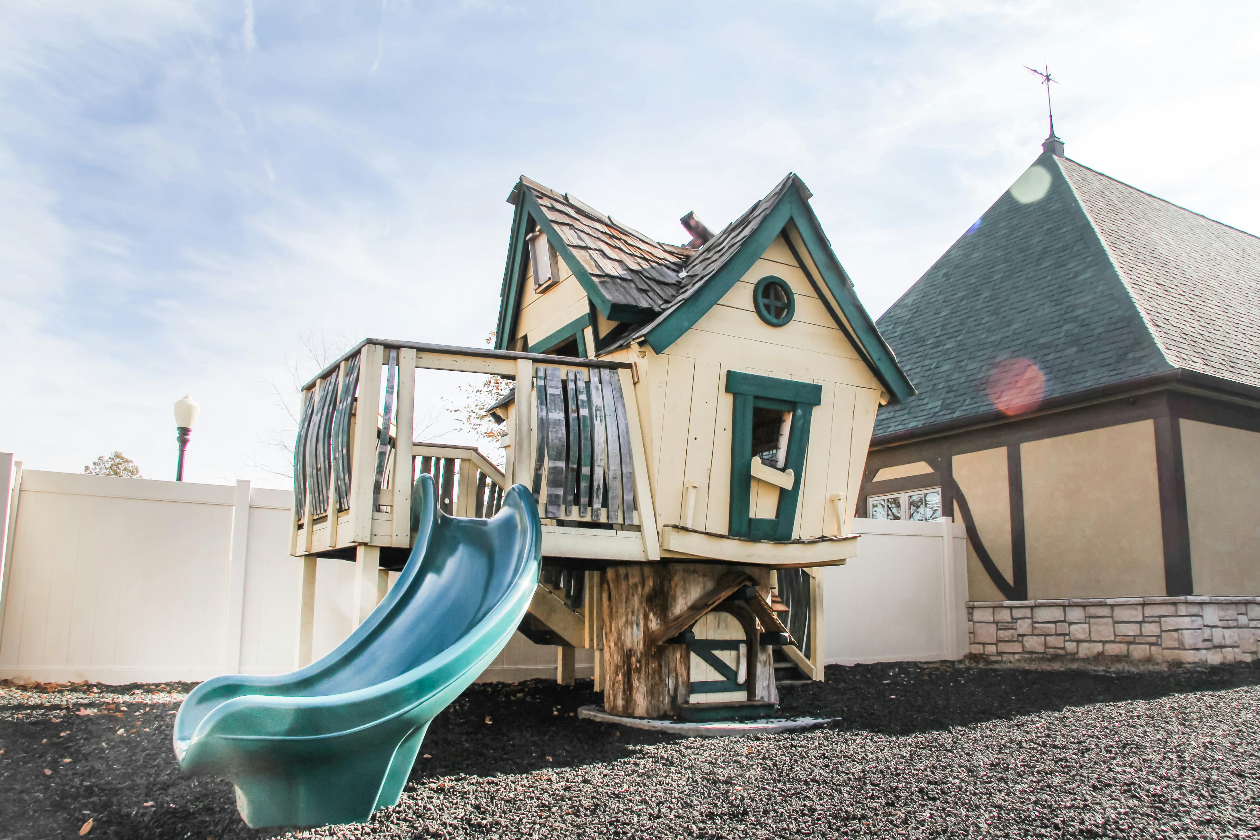 Playhouse with a slide next to a building