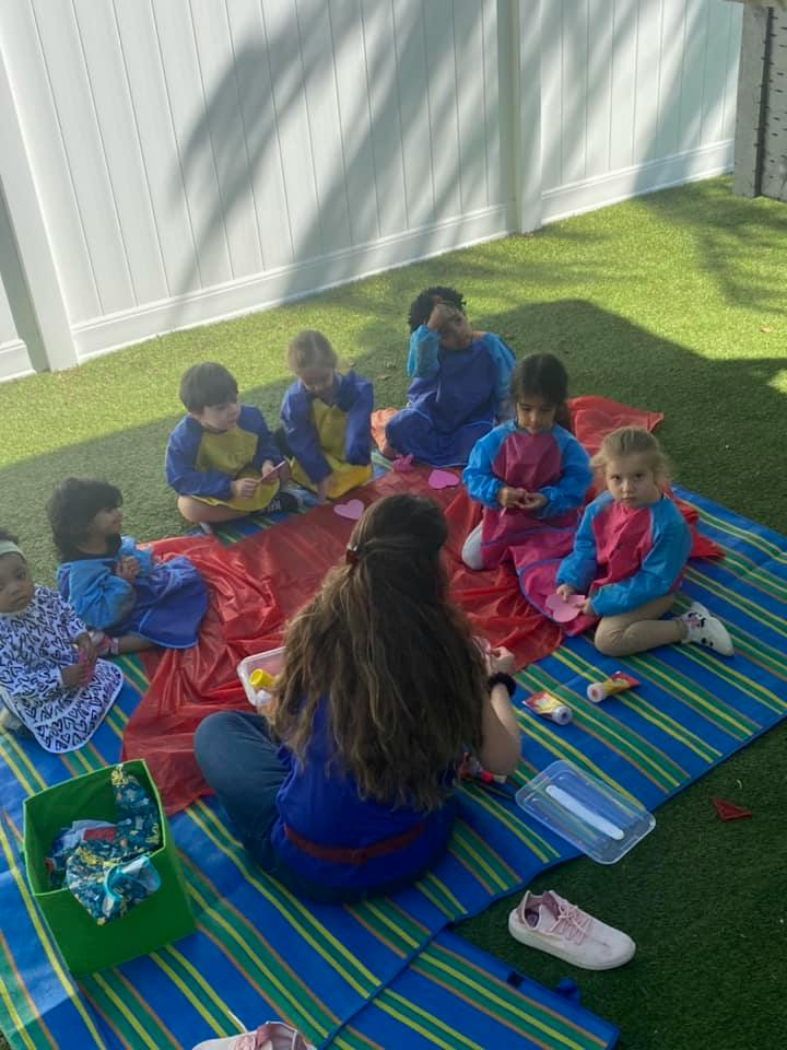 Adult and children sitting on blankets on grass