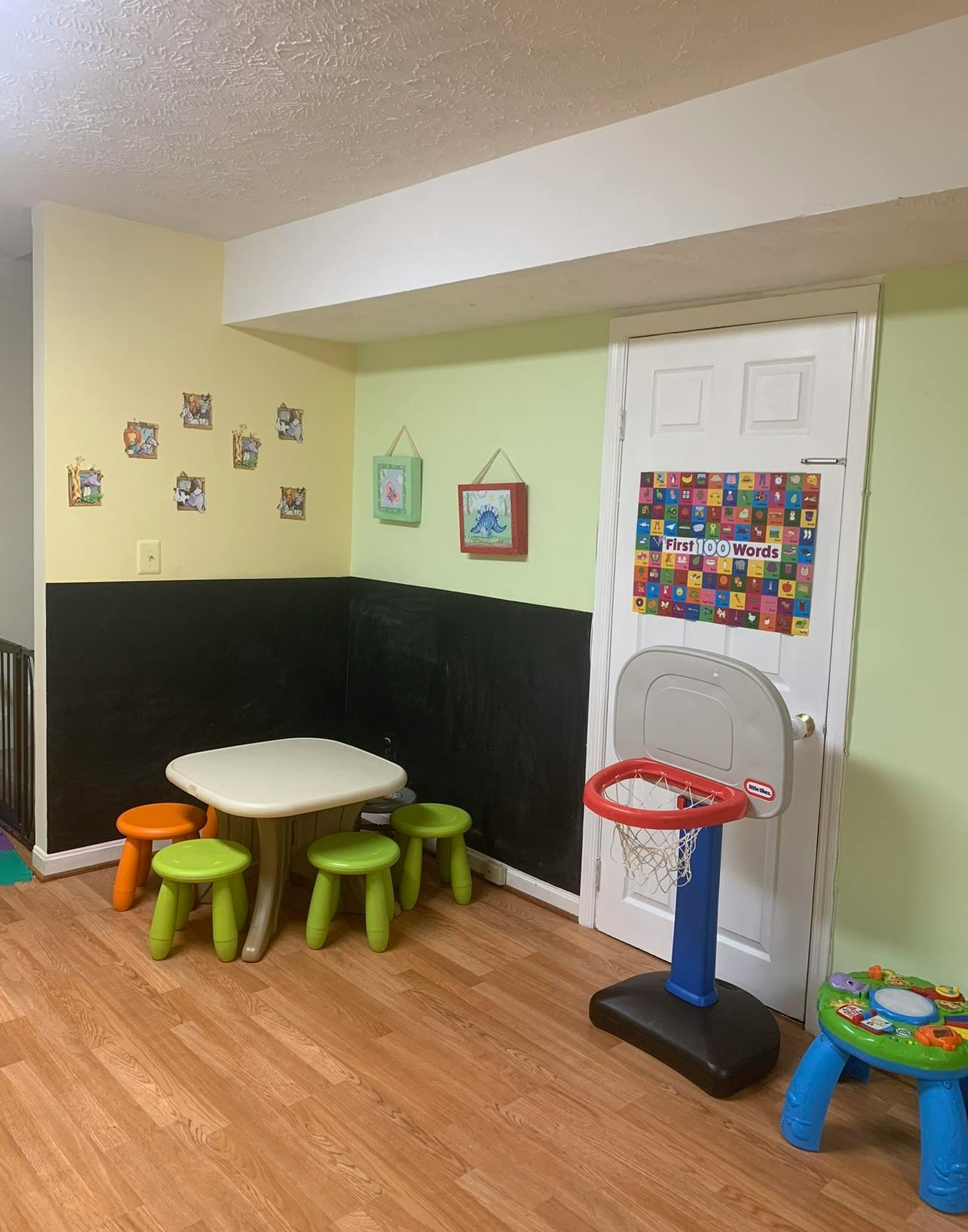 Children's play area with small table, stools, and toy basketball hoop