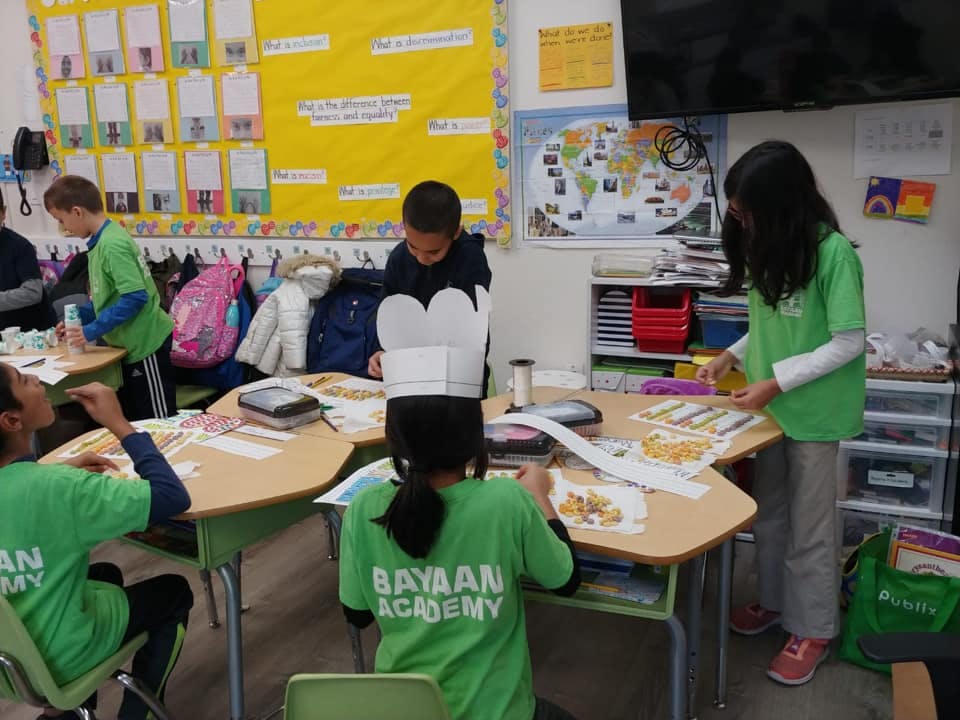 Children working on crafts at tables in a classroom