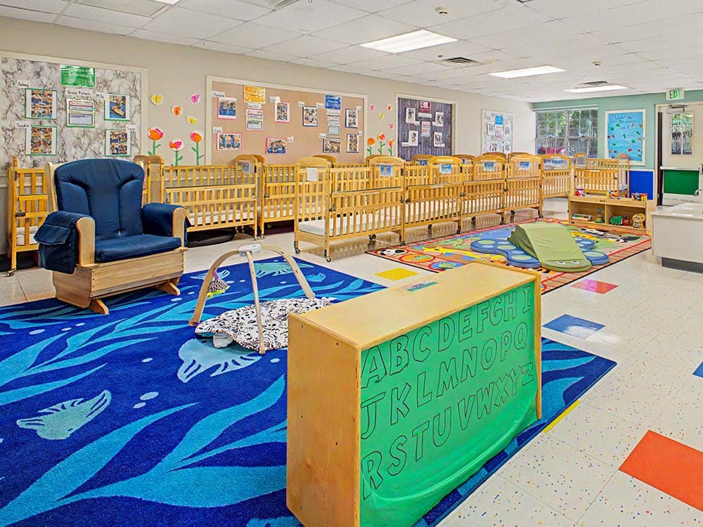 Cribs and child-sized furniture in a daycare room