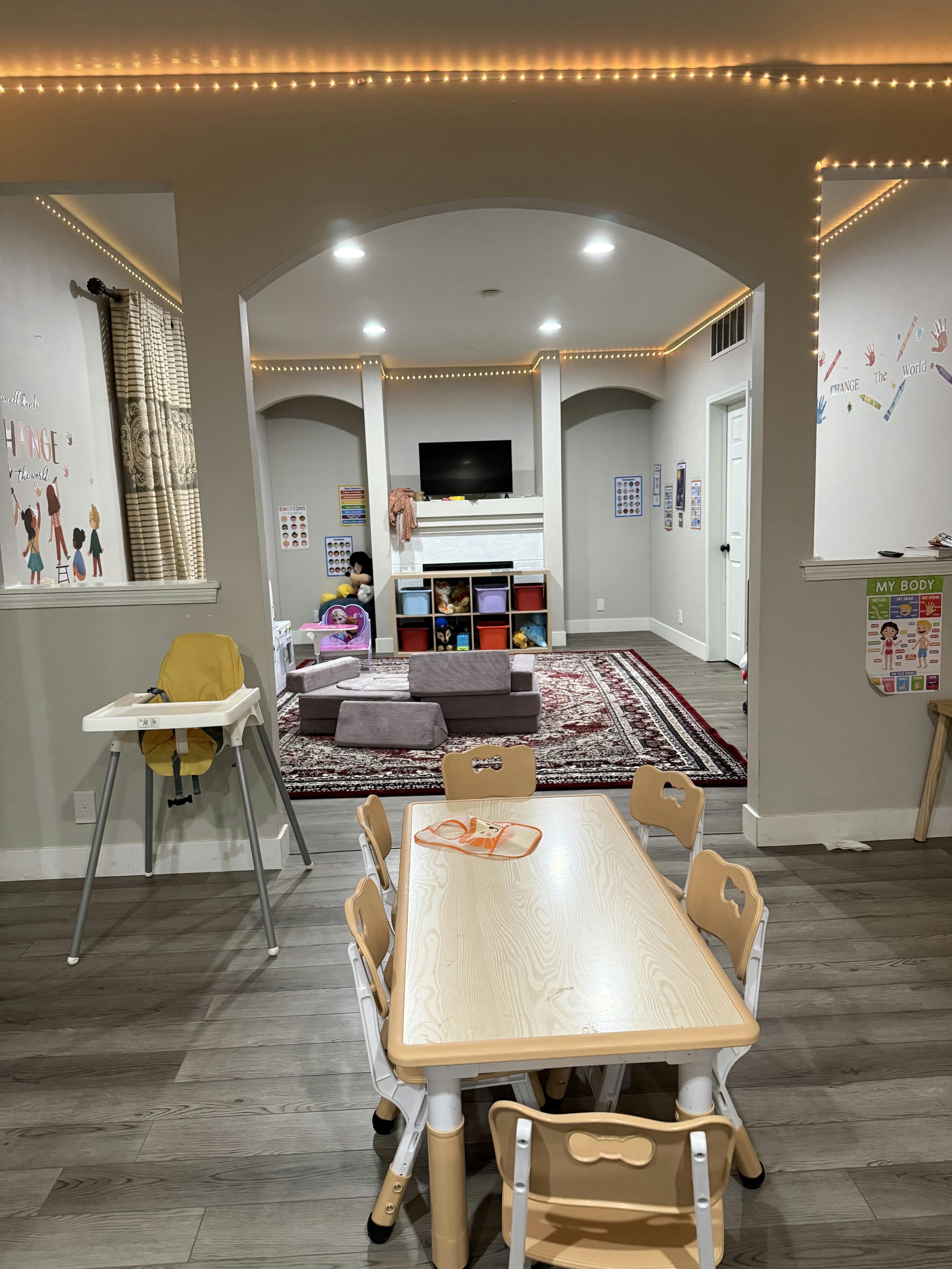 Child-sized table and chairs in a home play area with a high chair