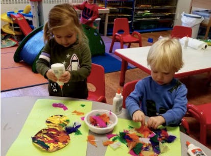 Two children doing crafts at a table