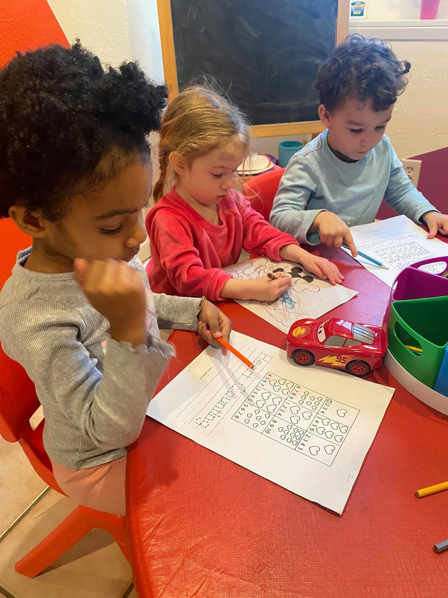 Three children coloring at a table