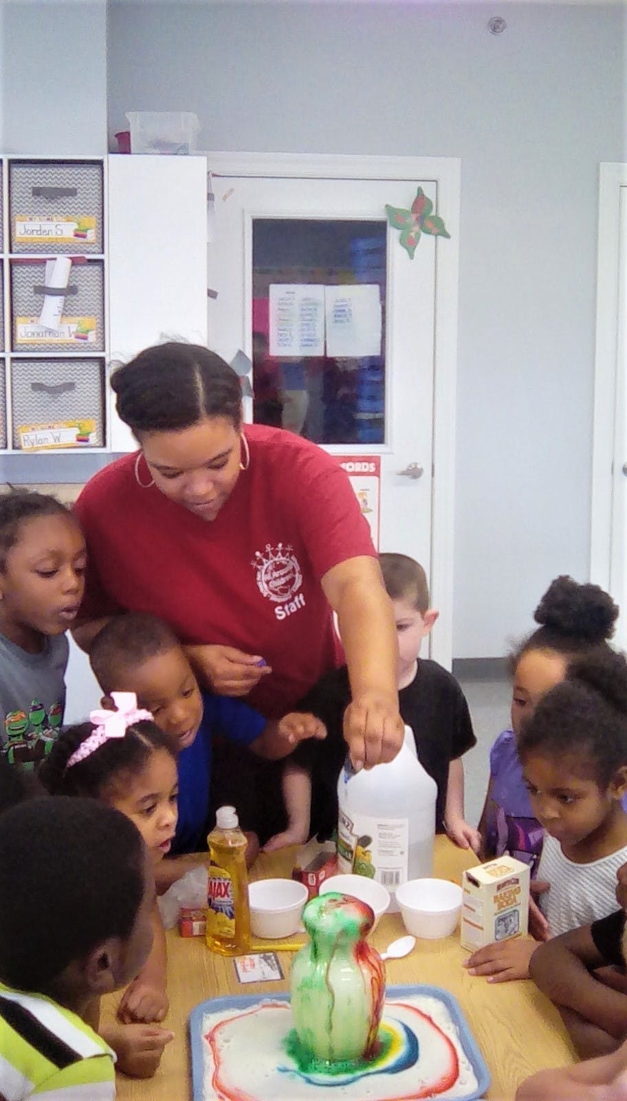 Person and children watching a science experiment with a volcano
