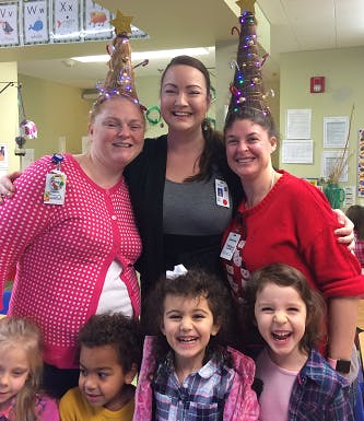 Three people with children, two people have hair styled like Christmas trees