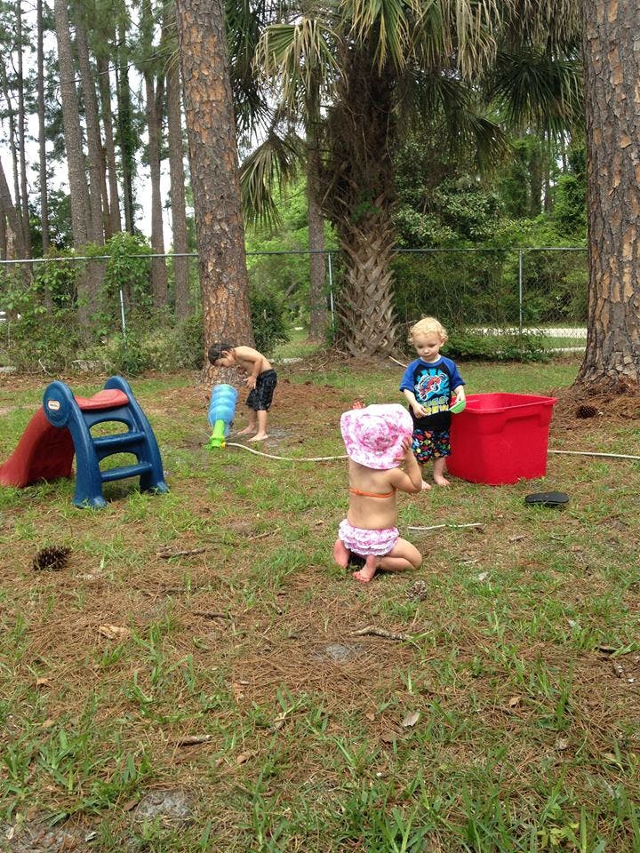 Children playing with water in a grassy yard