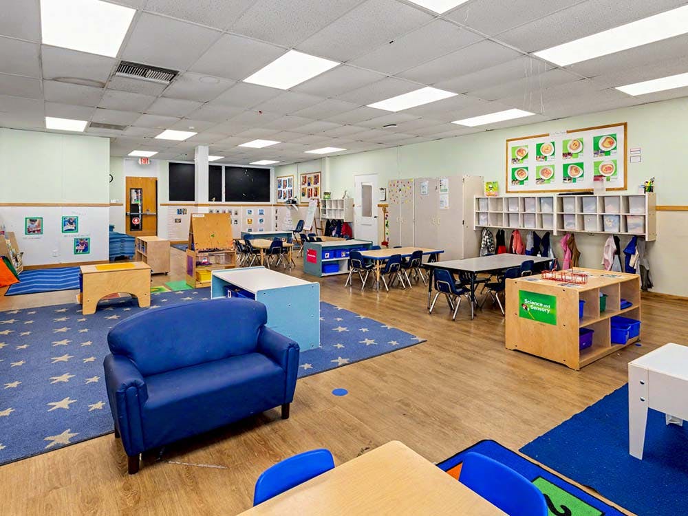 Empty colorful classroom with small tables and chairs