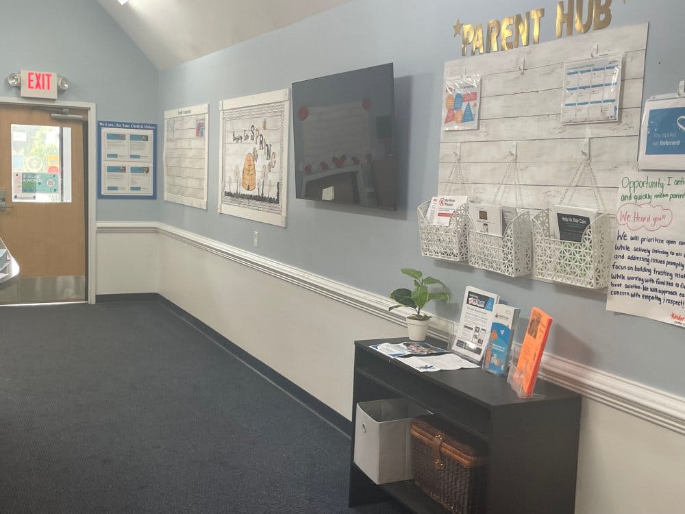 Hallway with an exit door, a TV, and a wall sign that says "PARENT HUB"