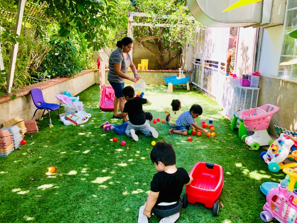 Adult and children playing with balls on artificial grass
