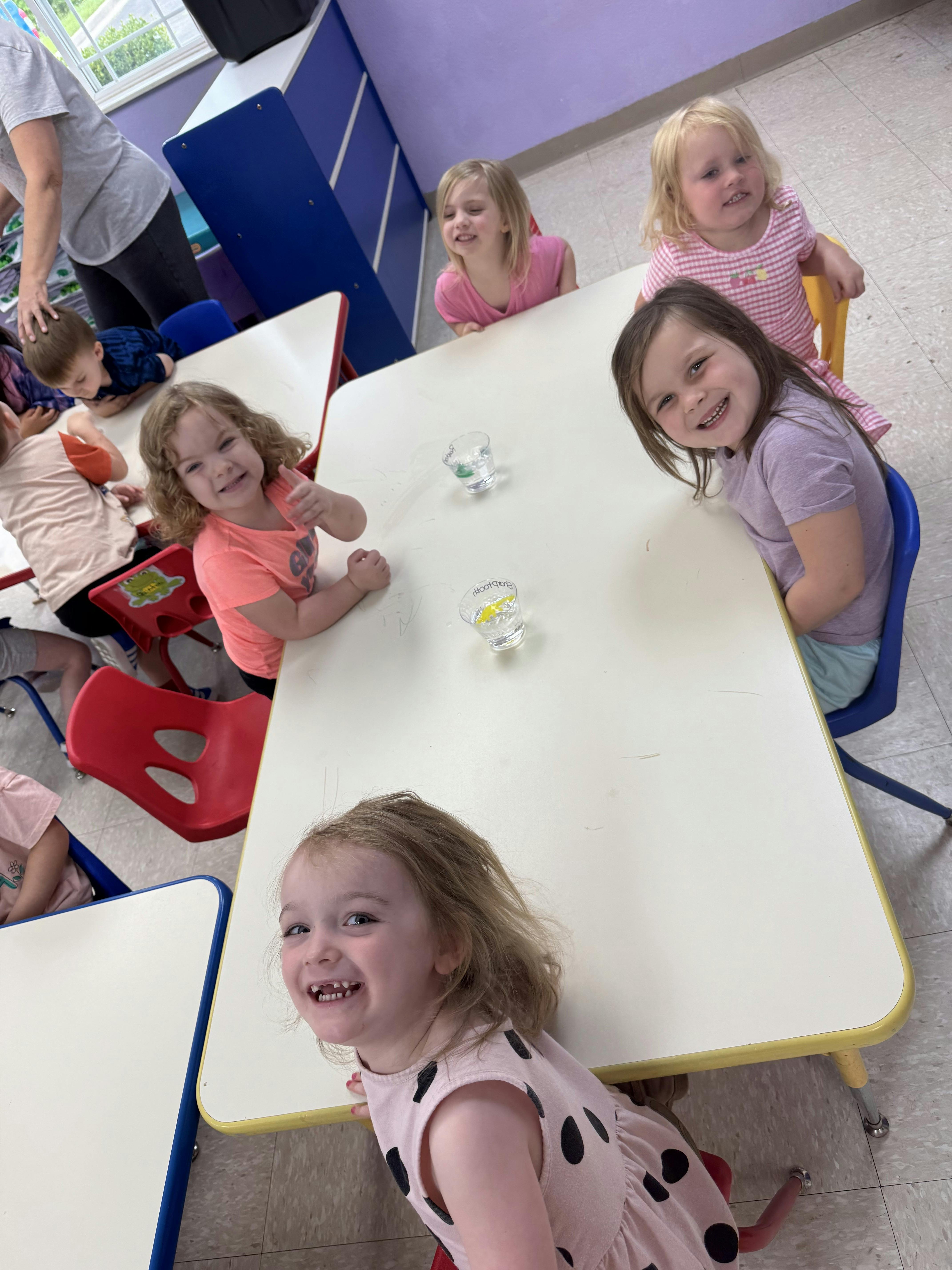 Children sitting at tables in a classroom