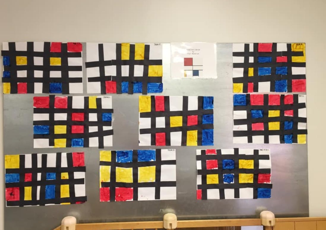 Multiple artworks with black grids and colored squares on a metallic surface