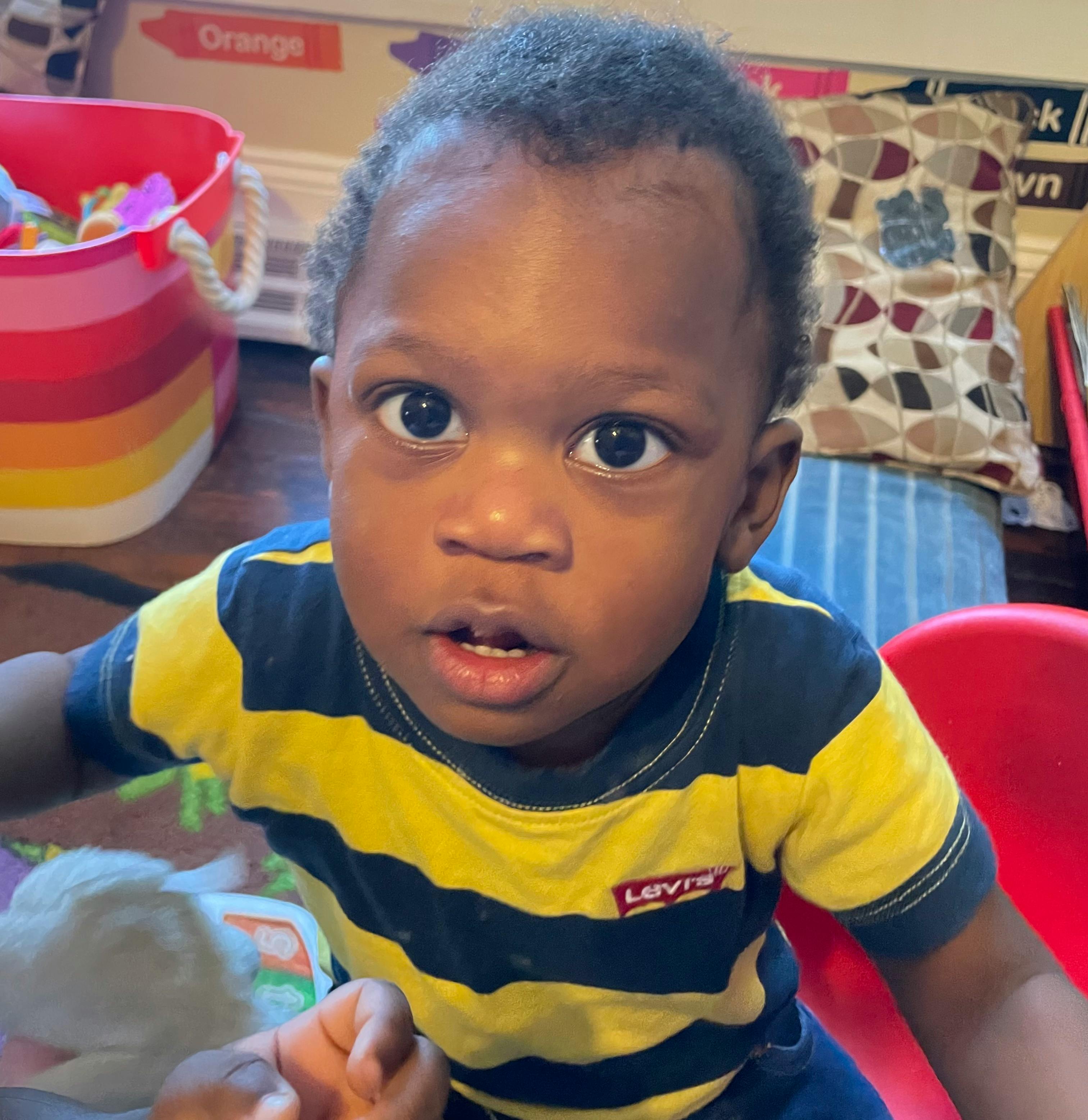 Child in a striped shirt looking forward