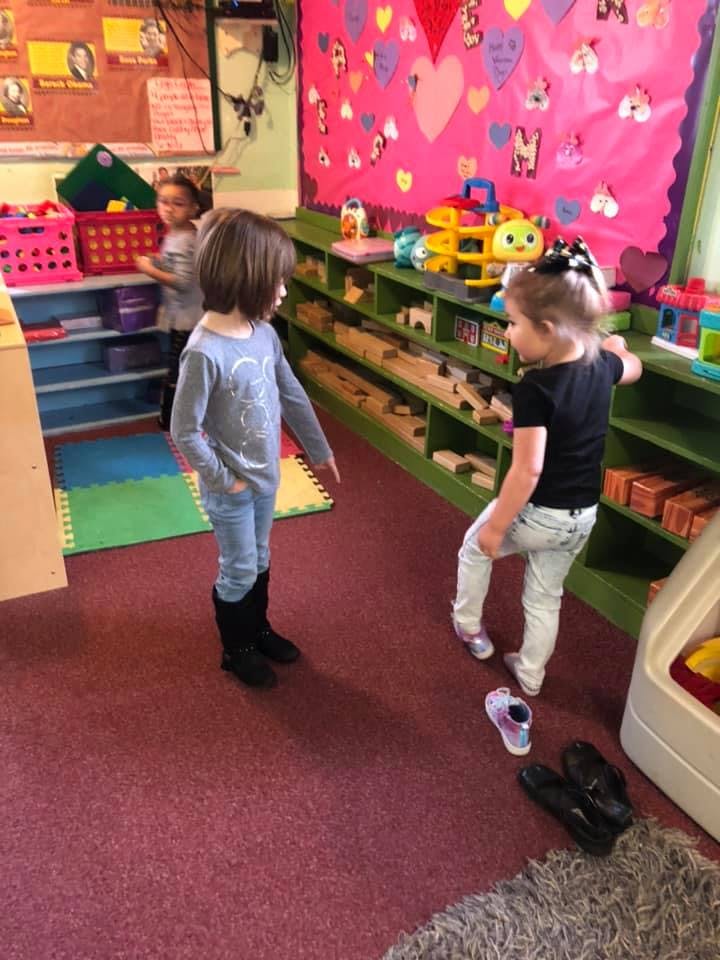 Two children standing in a classroom