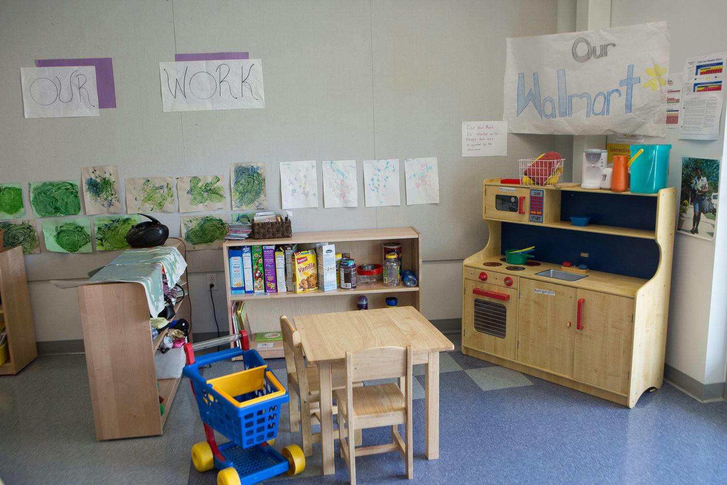 Playroom with toy kitchen, table and chairs, and shopping cart