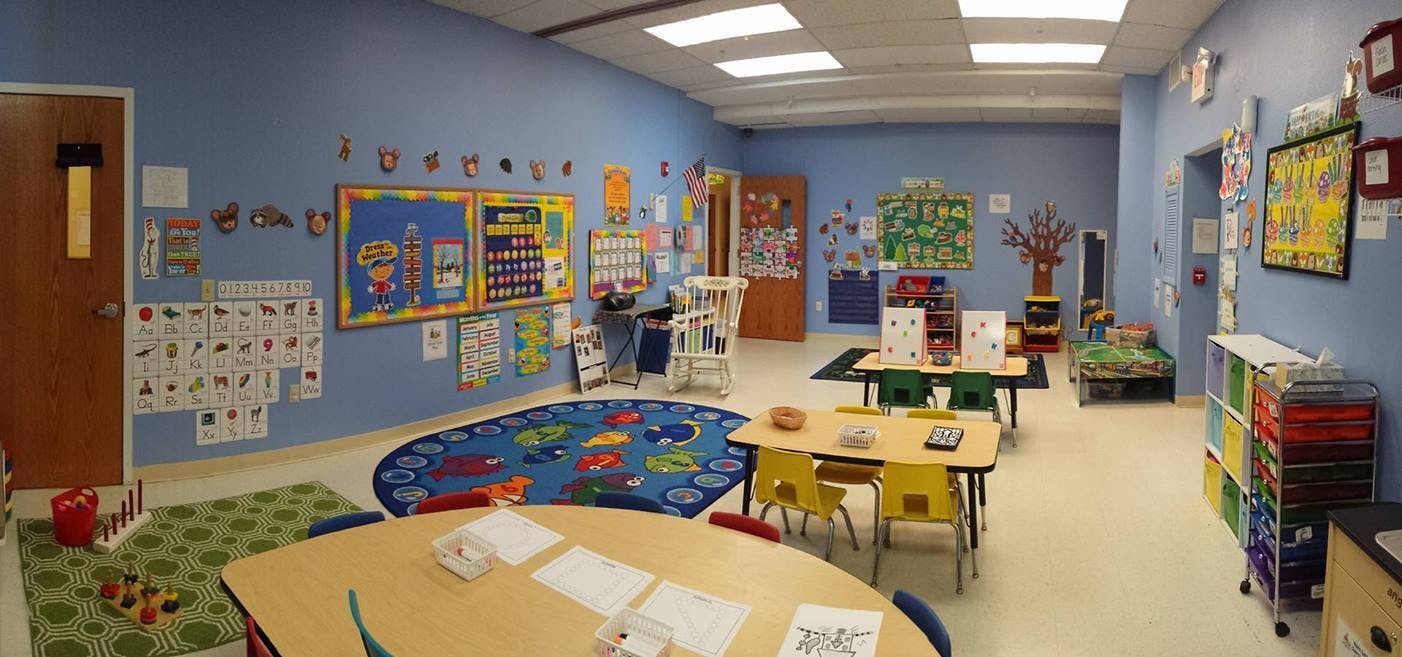 Classroom with tables, chairs, and colorful decorations on the walls