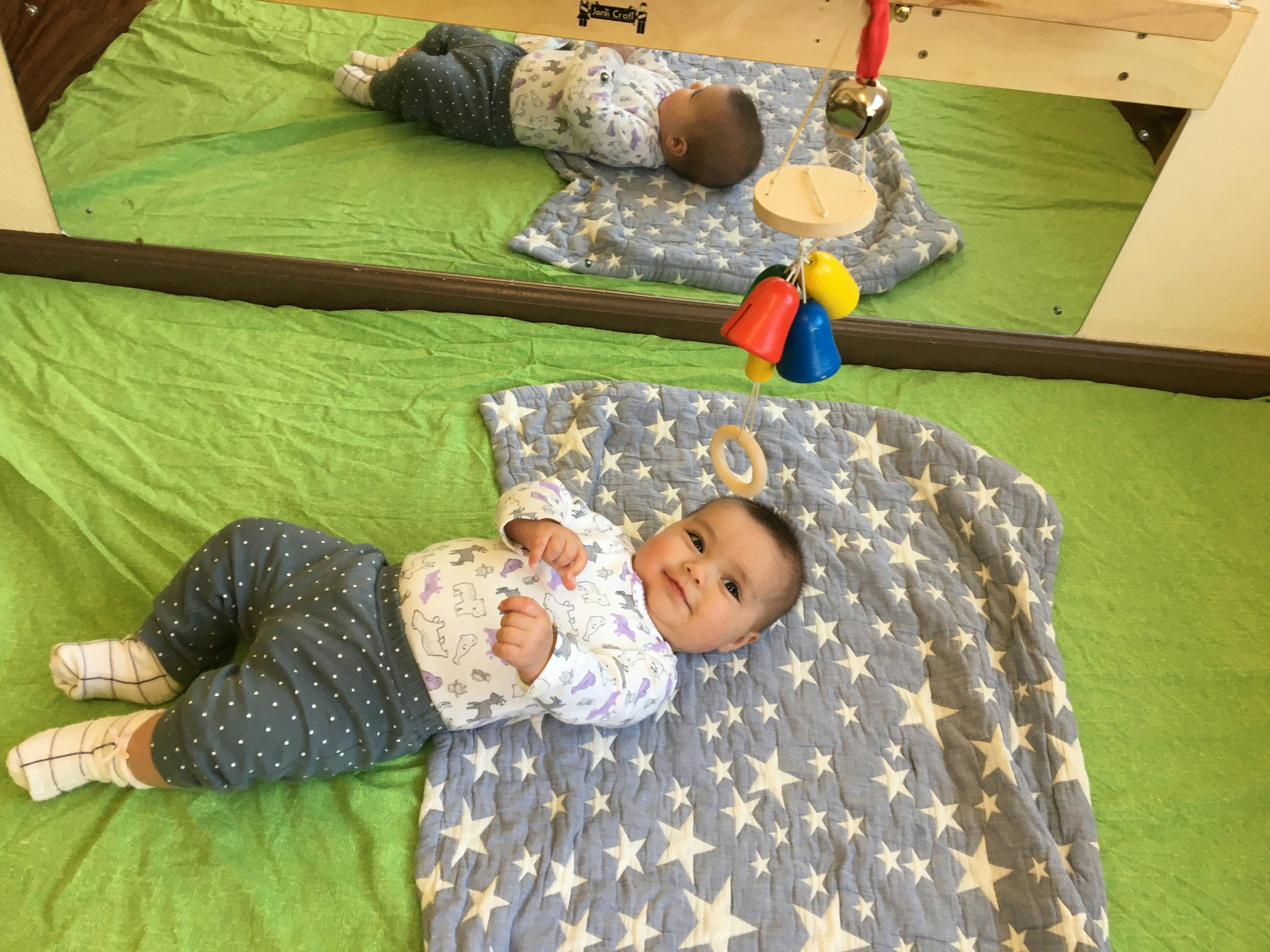 Baby lying on a blanket with a toy