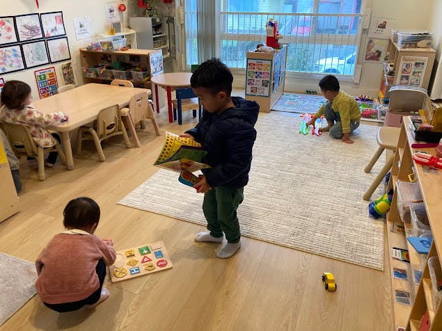 Children playing with toys and books in a classroom
