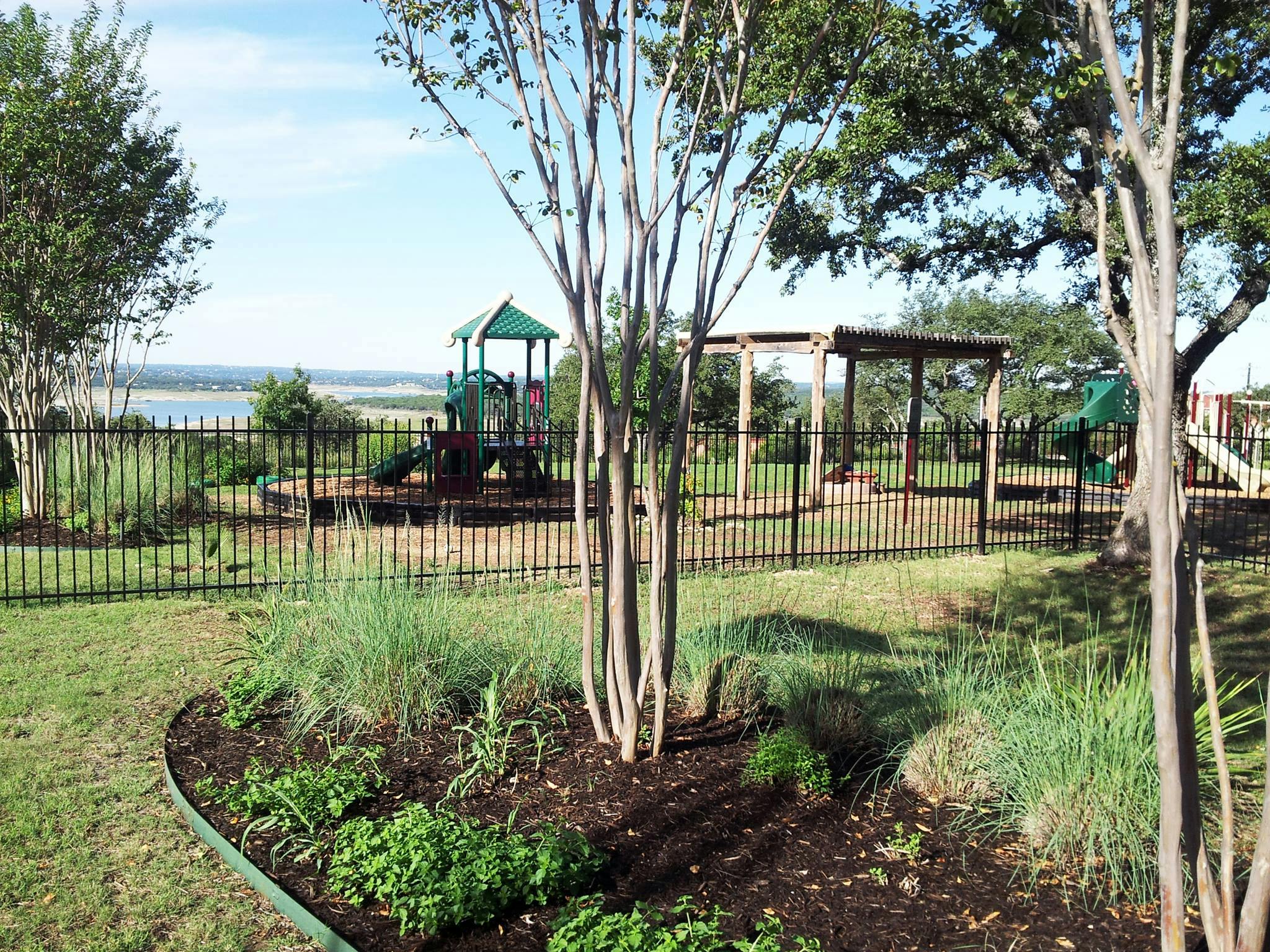 Playground with swings and slides behind a fence
