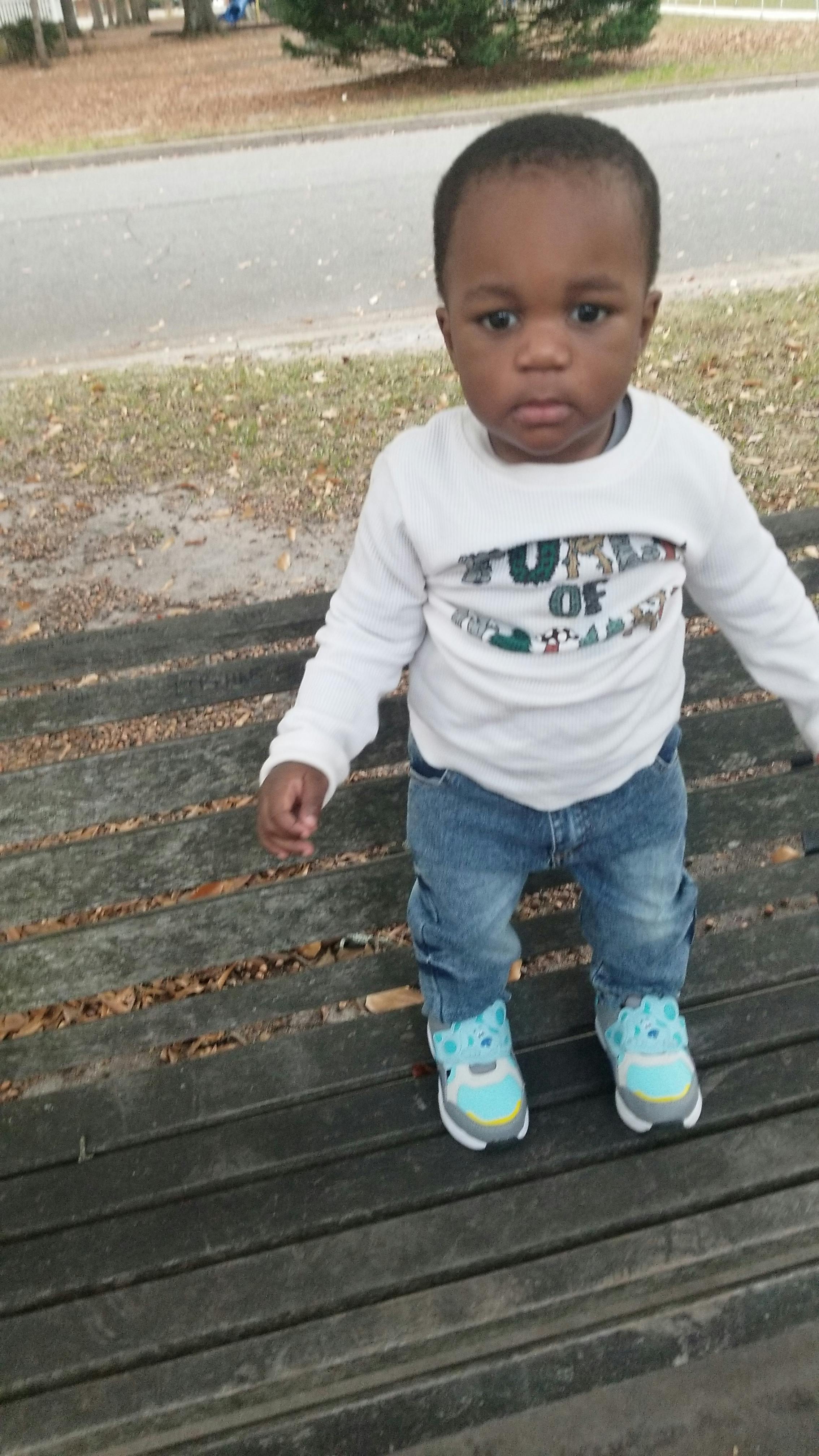Child standing on a wooden surface