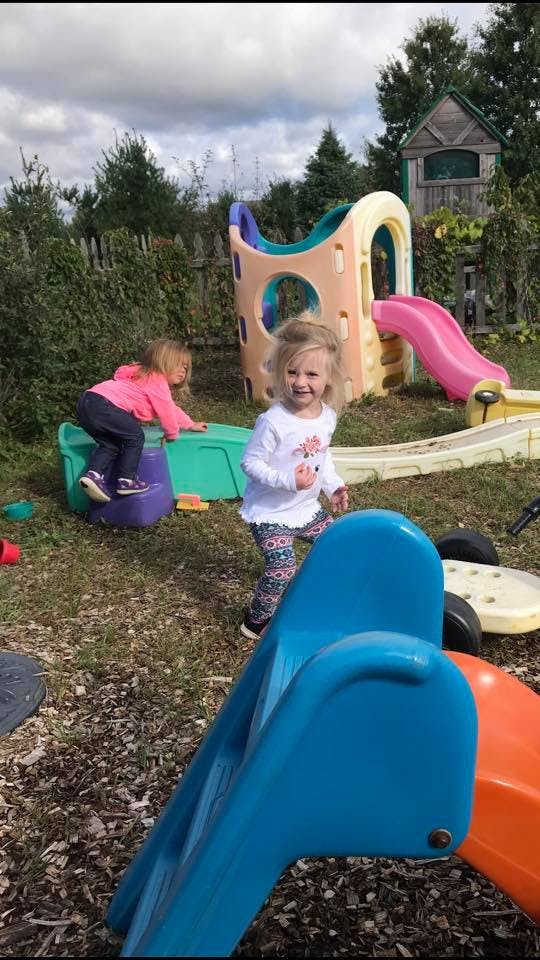 Two children playing on outdoor playground equipment