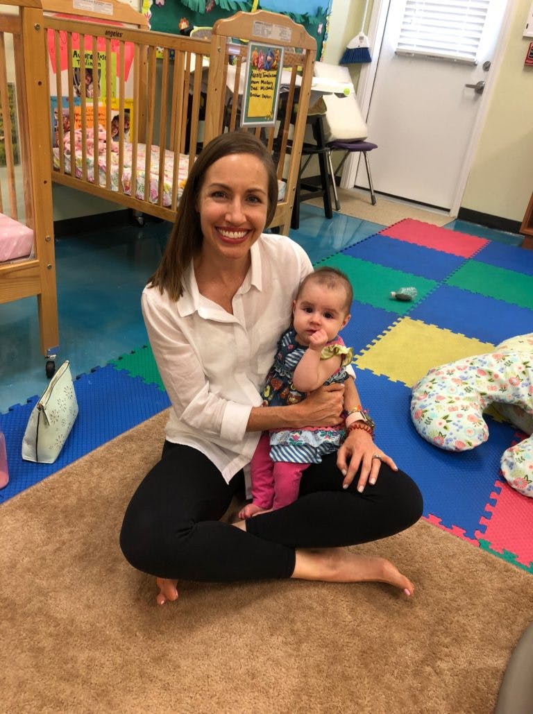 Person sitting on floor holding a child