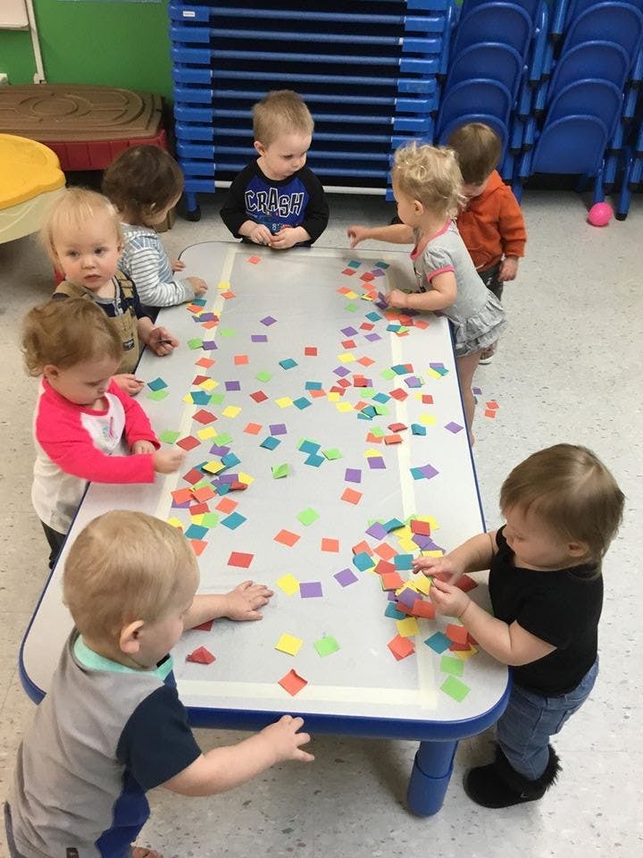 Children playing with colorful squares on a table